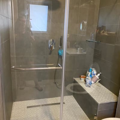 מקלחון זכוכית עם ראש מקלחת ומוצרי טיפוח