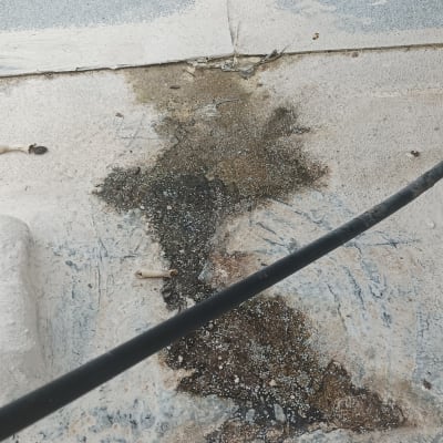 כתם רטיבות על רצפה עם צינור שחור