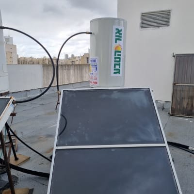 דוד שמש עם קולטים על גג תחת שמיים מעוננים