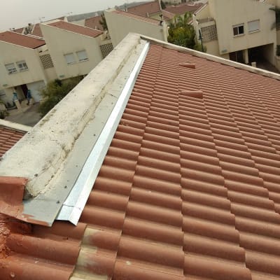 גג רעפים אדומים עם פס מתכת לאורך הקצה