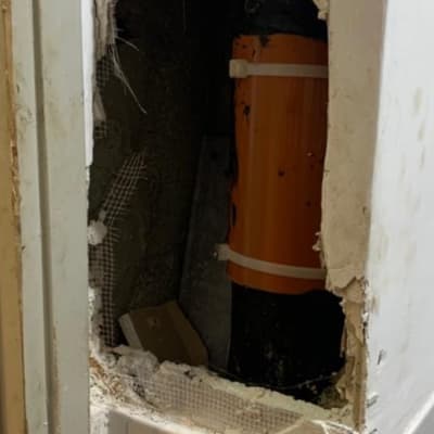 צינור כתום בקיר פתוח עם תיקון טיח