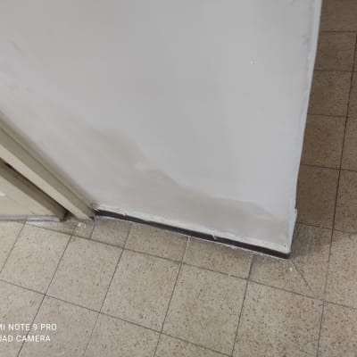 קיר צבוע בלבן עם סימני תיקון צבע