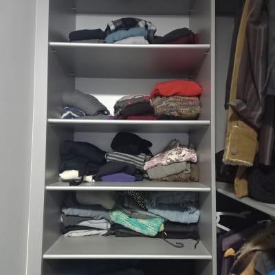 בגדים מקופלים על מדפים בארון פתוח