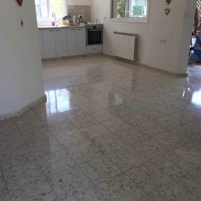 אדם מנקה רצפה עם מכונת שטיפה