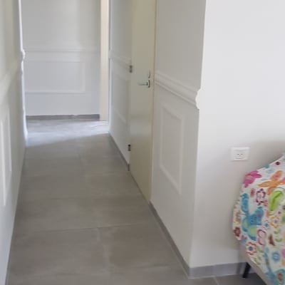 מסדרון עם קירות לבנים ודלתות צבועות