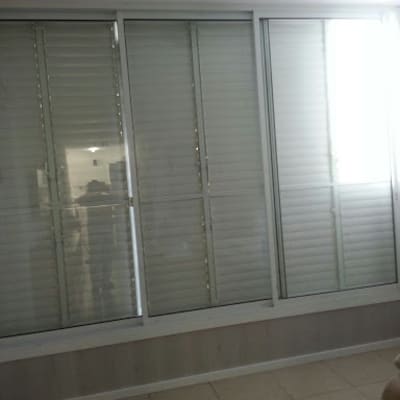 חלונות אלומיניום עם תריסים סגורים בחדר מואר