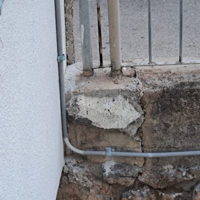 צינור חשמל אפור מחובר לקיר עם תפסנים