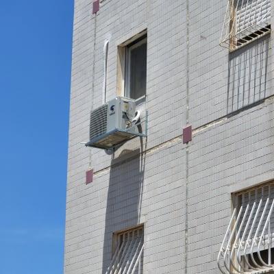 יחידת מזגן מותקנת על קיר חיצוני של בניין