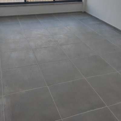 רצפה נקייה עם אריחים אפורים ליד חלון גדול