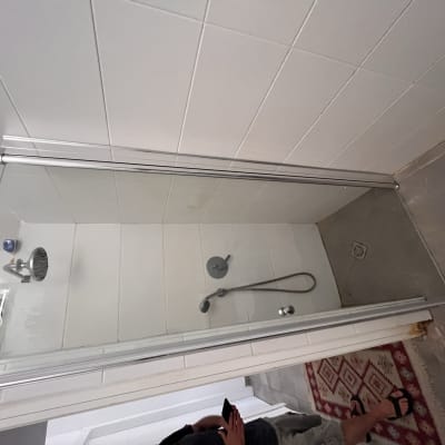 מקלחת עם ראש מקלחת ודלת זכוכית