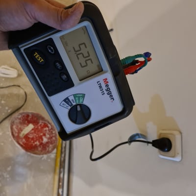 מד מתח חשמלי מחובר לשקע בקיר