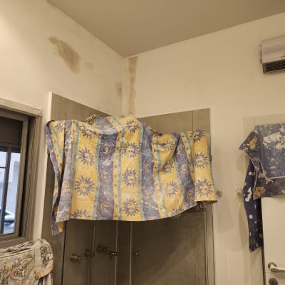 קירות עם כתמי רטיבות ומגבות תלויות להגנה