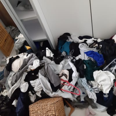 בגדים מפוזרים על הרצפה עם קולבים