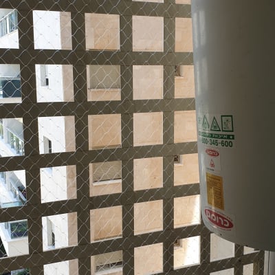 רשת מתכת על חלון למניעת כניסת יונים