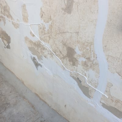 קיר עם סדקים אטומים בחומר איטום לבן