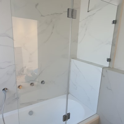 מקלחון זכוכית עם אמבטיה וברזים כסופים