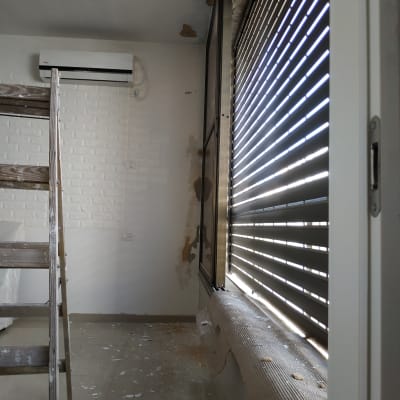 סולם עץ, קיר מתקלף, שאריות צבע על הרצפה