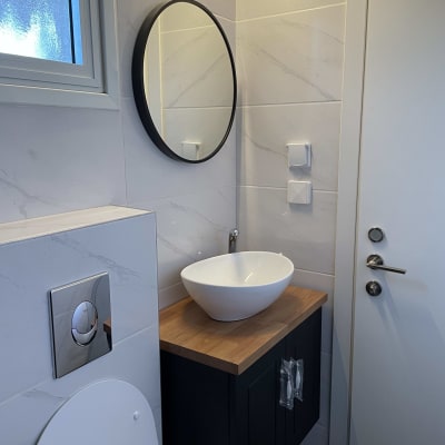 כיור עגול על משטח עץ בחדר אמבטיה מודרני