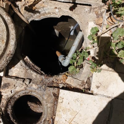 פתח ביוב עם צינור פלסטיק ומים עומדים