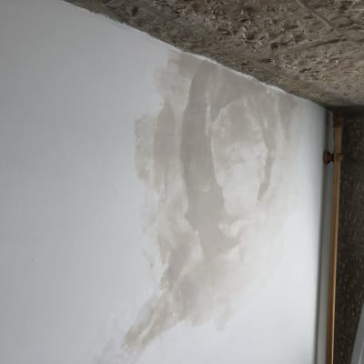 קיר עם תיקוני צבע וטיח חלקי