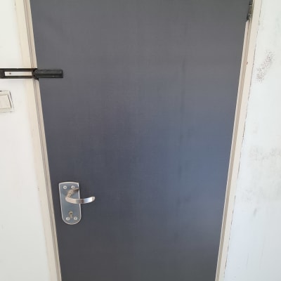 דלת מצופה בציפוי כהה עם ידית מתכת כסופה