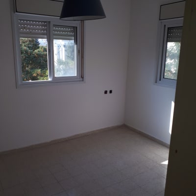 חדר ריק עם קירות לבנים ותאורה טבעית