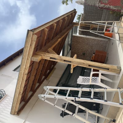 פרגולה מעץ עם סולם מתכת בחצר