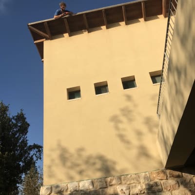 אדם עומד על גג עם כלי עבודה ביד