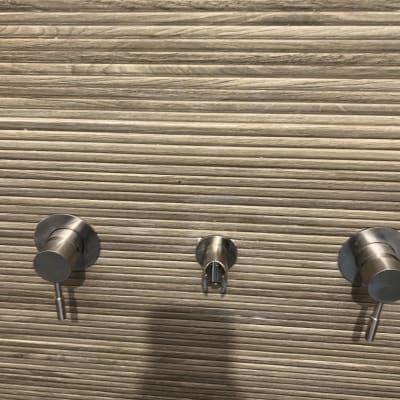 ברזים מותקנים על קיר עץ מחורץ