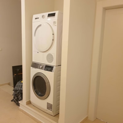מכונת כביסה ומייבש בערימה בתוך נישה בקיר