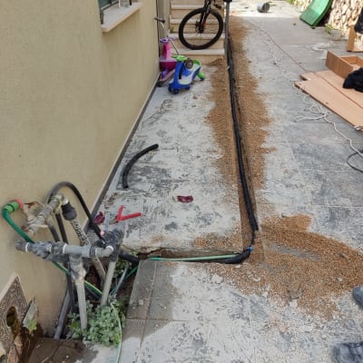 צינורות מים וכלי עבודה ליד קיר חיצוני