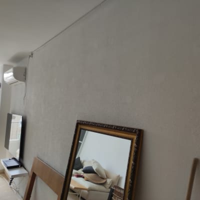 קיר צבוע בלבן עם מסגרת מראה מונחת על הרצפה