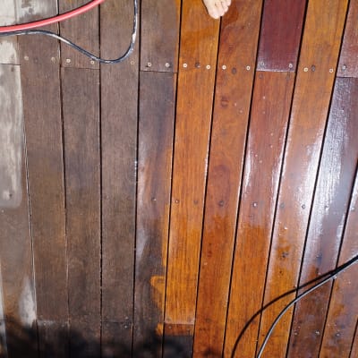 משטח עץ רטוב עם כבלים אדומים ושחורים