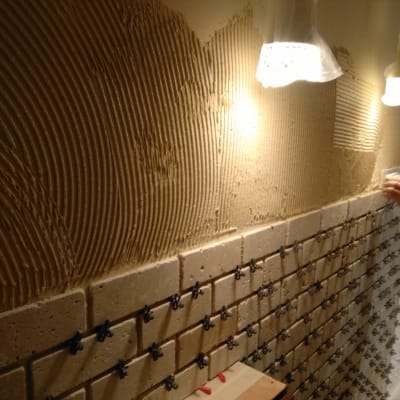 הנחת אריחים על קיר עם דבק וטיח