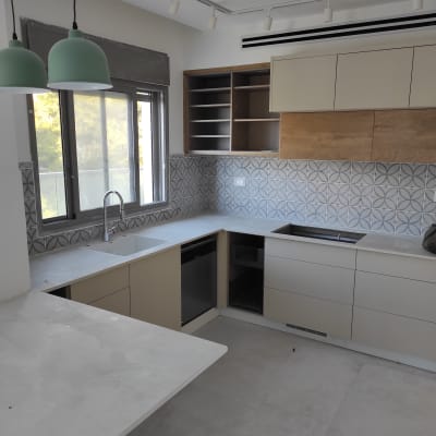 מטבח עם משטחי עבודה נקיים וכיור ריק