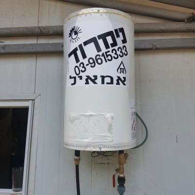 דוד שמש מותקן על קיר עם צינורות חיבורים