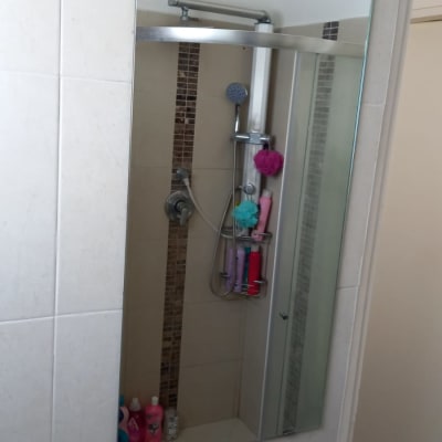 מראה מלבנית תלויה על קיר חדר אמבטיה