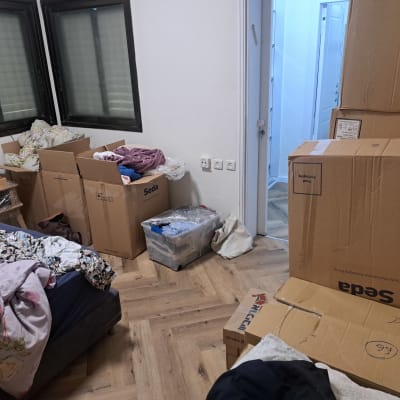 חדר עם קופסאות קרטון ואריזות בגדים
