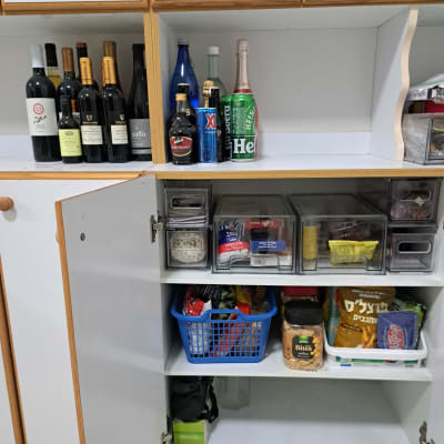 ארון מטבח מאורגן עם בקבוקי יין ומזון