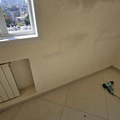 קיר עם סימני צבע וכלי עבודה על הרצפה