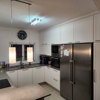 מטבח מודרני עם ארונות לבנים ומקרר נירוסטה