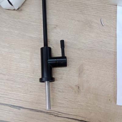 ברז שחור על שולחן עץ עם קופסה לבנה