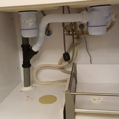 צנרת מתחת לכיור עם חיבורים וצינורות