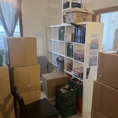 חדר עם קופסאות קרטון ומדפים מלאים