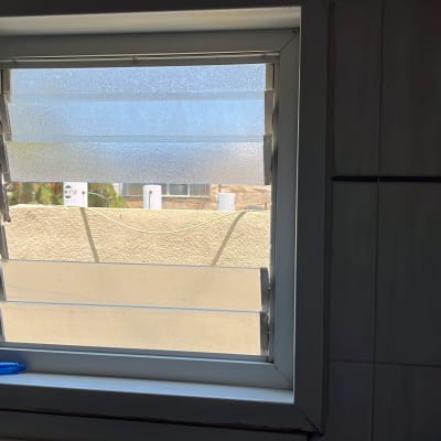 תריסים פתוחים למחצה בחלון עם אור שמש