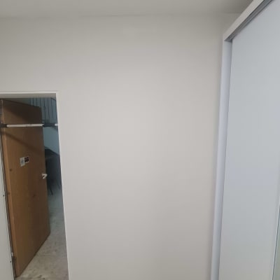 קיר צבוע בלבן עם דלת פתוחה בצד