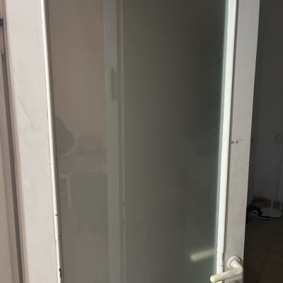 דלת זכוכית עם מסגרת לבנה וידית בצבע קרם