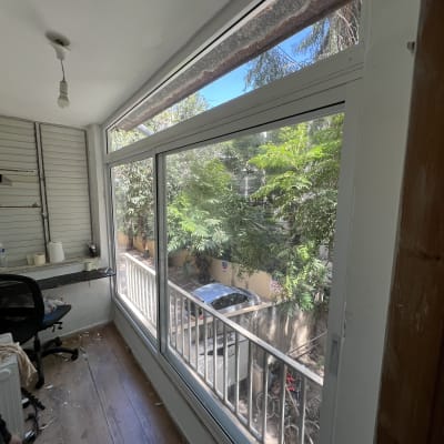 חלון אלומיניום גדול עם נוף לעצים בחוץ