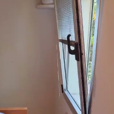 תריסים על חלון פתוח עם ידית שחורה