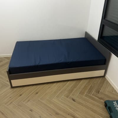 מיטה בחדר עם רצפת פרקט וחלון